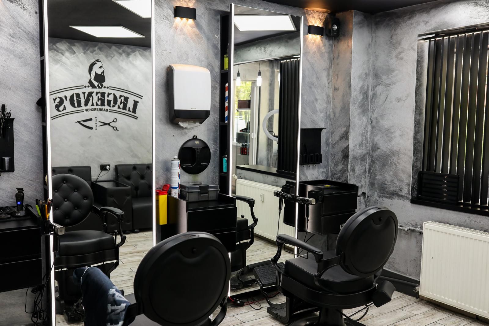 Interiorul Legends Barbershop cu scaune negre și oglinzi luminate